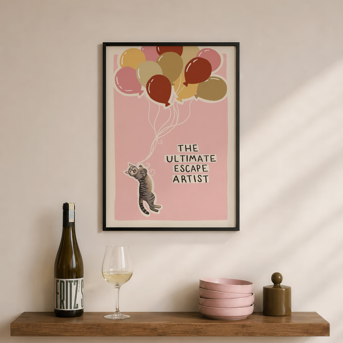 Framed cat print artwork with balloon cluster in pink and a gray tabby cat, text centered.