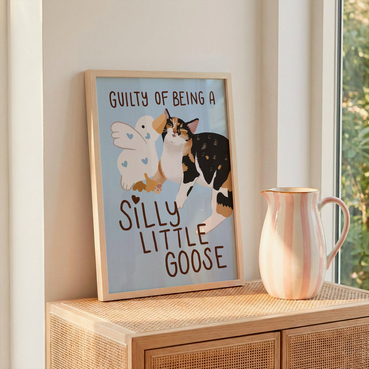 Unframed goose and cat illustration print with “Silly Little Goose” on light blue