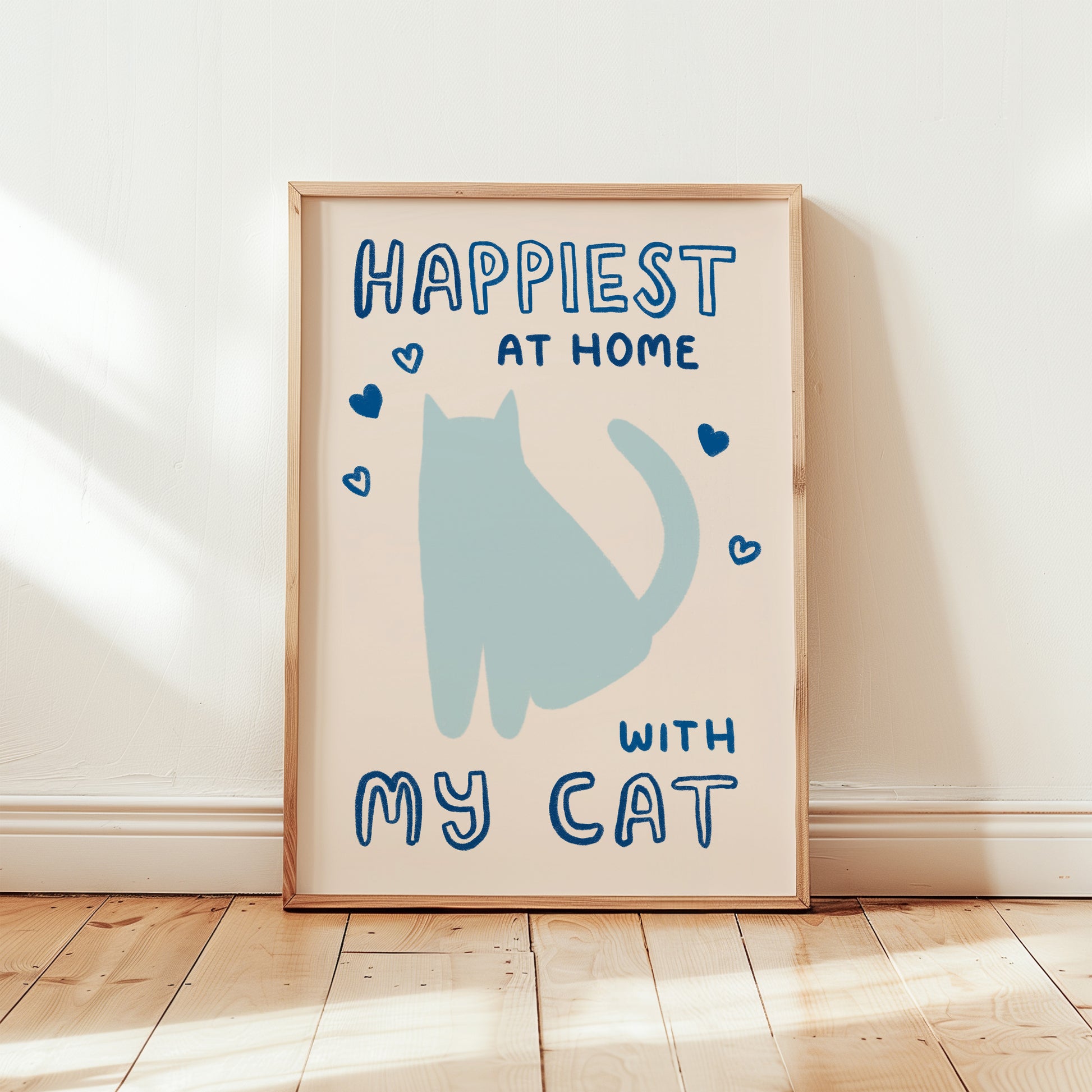 Happiest at Home print with blue cat, dark blue hearts, “with my cat” in wood frame
