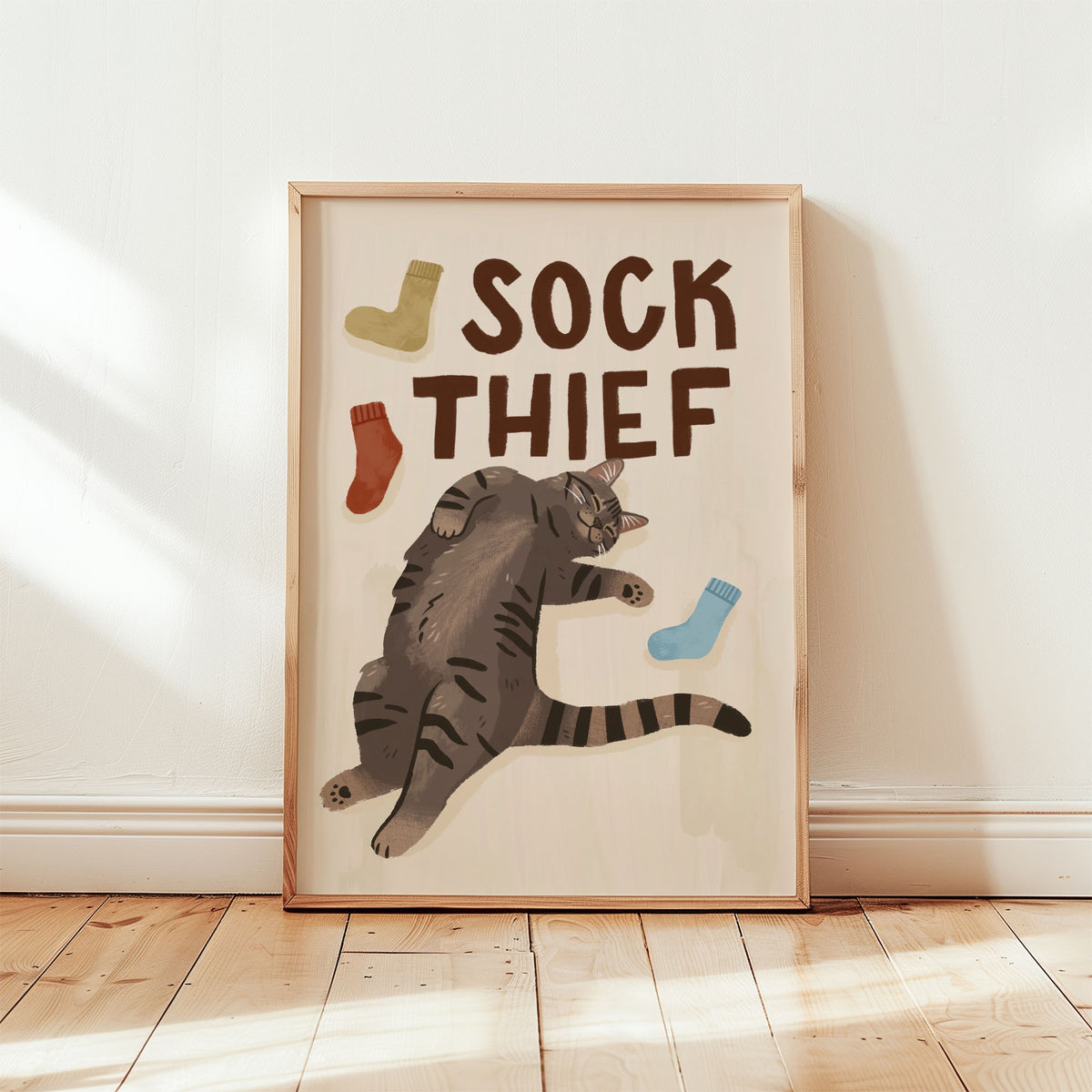 Framed cat print: 'SOCK THIEF' lettering, gray tabby cat and blue, red, and green socks