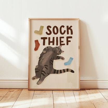 Framed cat print: 'SOCK THIEF' lettering, gray tabby cat and blue, red, and green socks