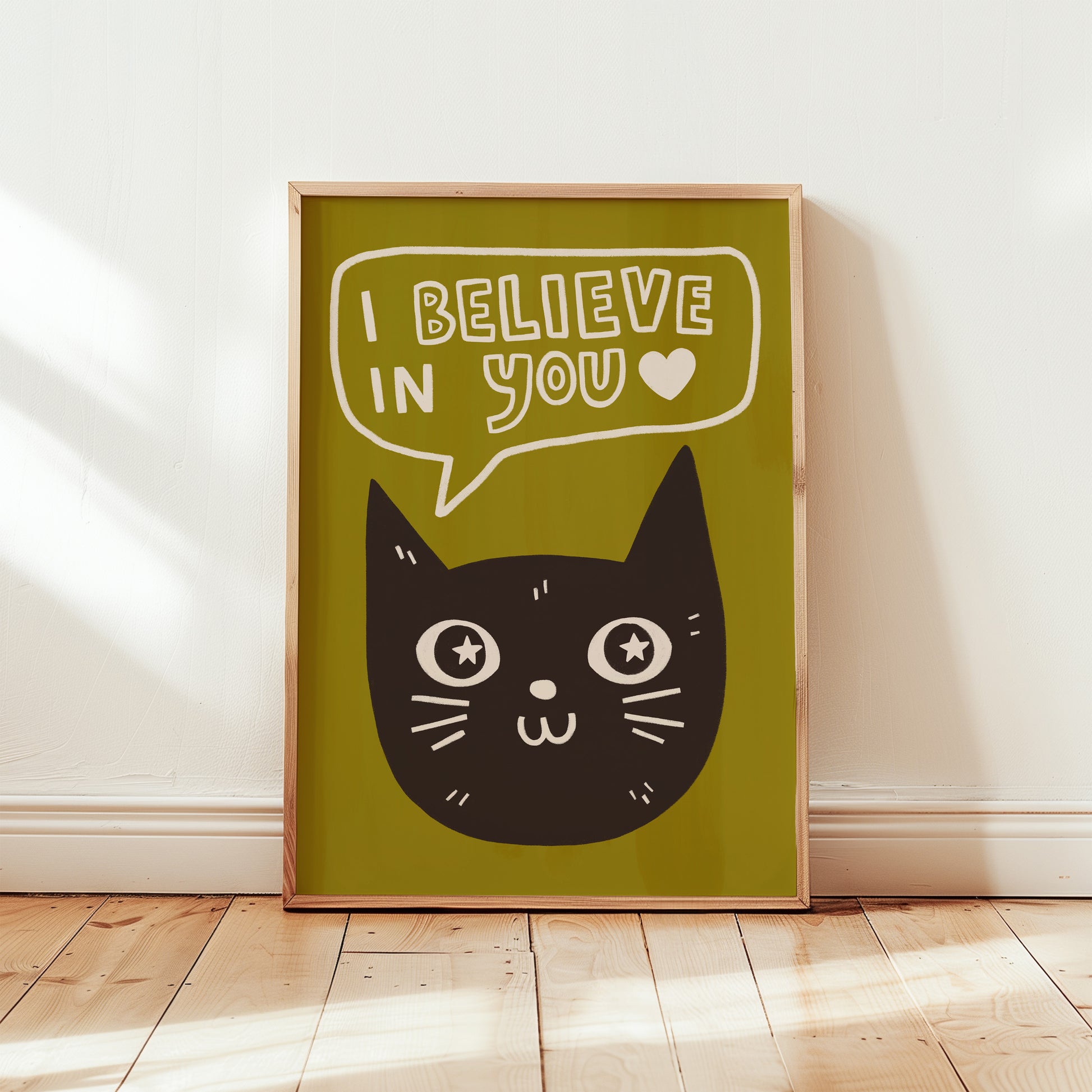 Unframed cat print wall art with black cat face and “I Believe in You” speech bubble on olive background