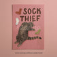 Unframed cat print: 'SOCK THIEF' text, gray cat reaching with colored sock icons