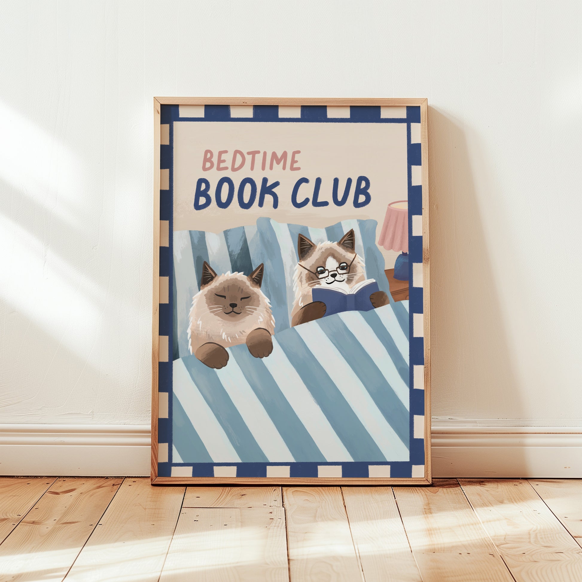 Bedtime Book Club cat print, unframed; blue striped bedding with two cats reading