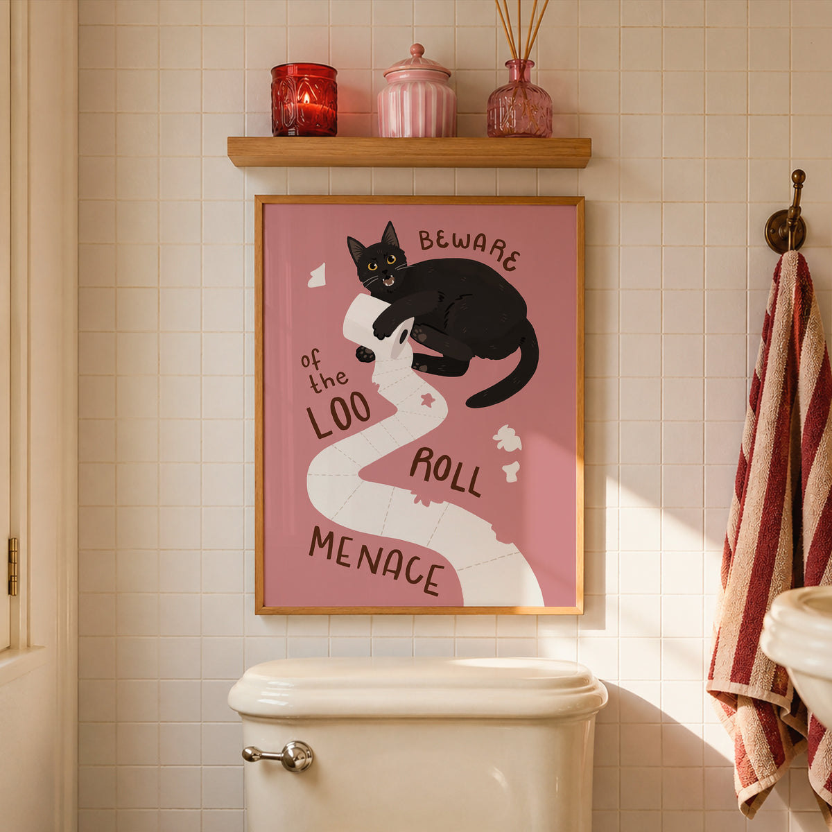 Cat toilet paper print in frame on tiled bathroom wall, pink background