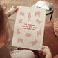 Unframed cat quote print held up, pink cats and red “THE FEMININE…ONE MORE CAT”