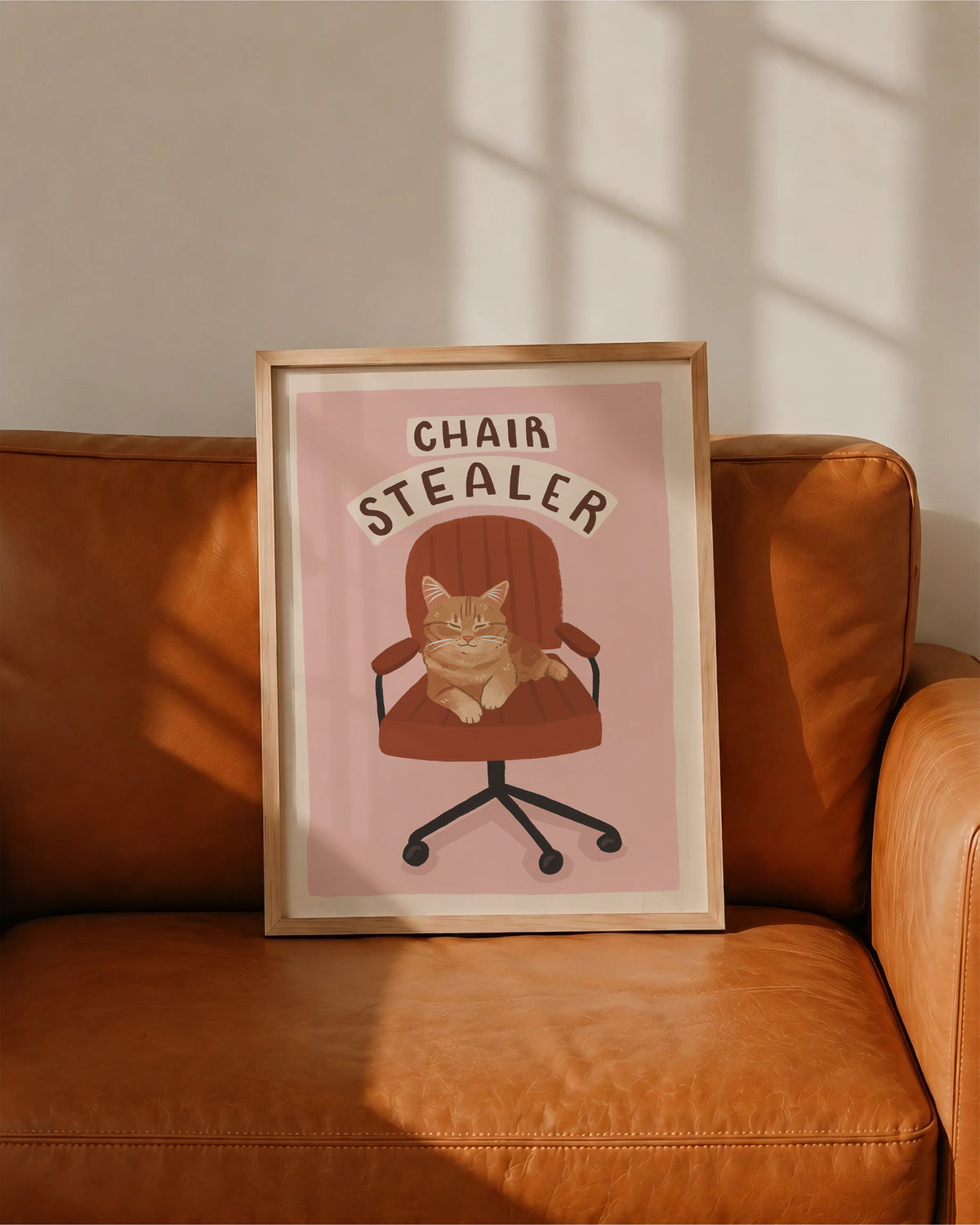 Cat office chair artwork print with orange tabby cat, 'CHAIR STEALER' text, in frame
