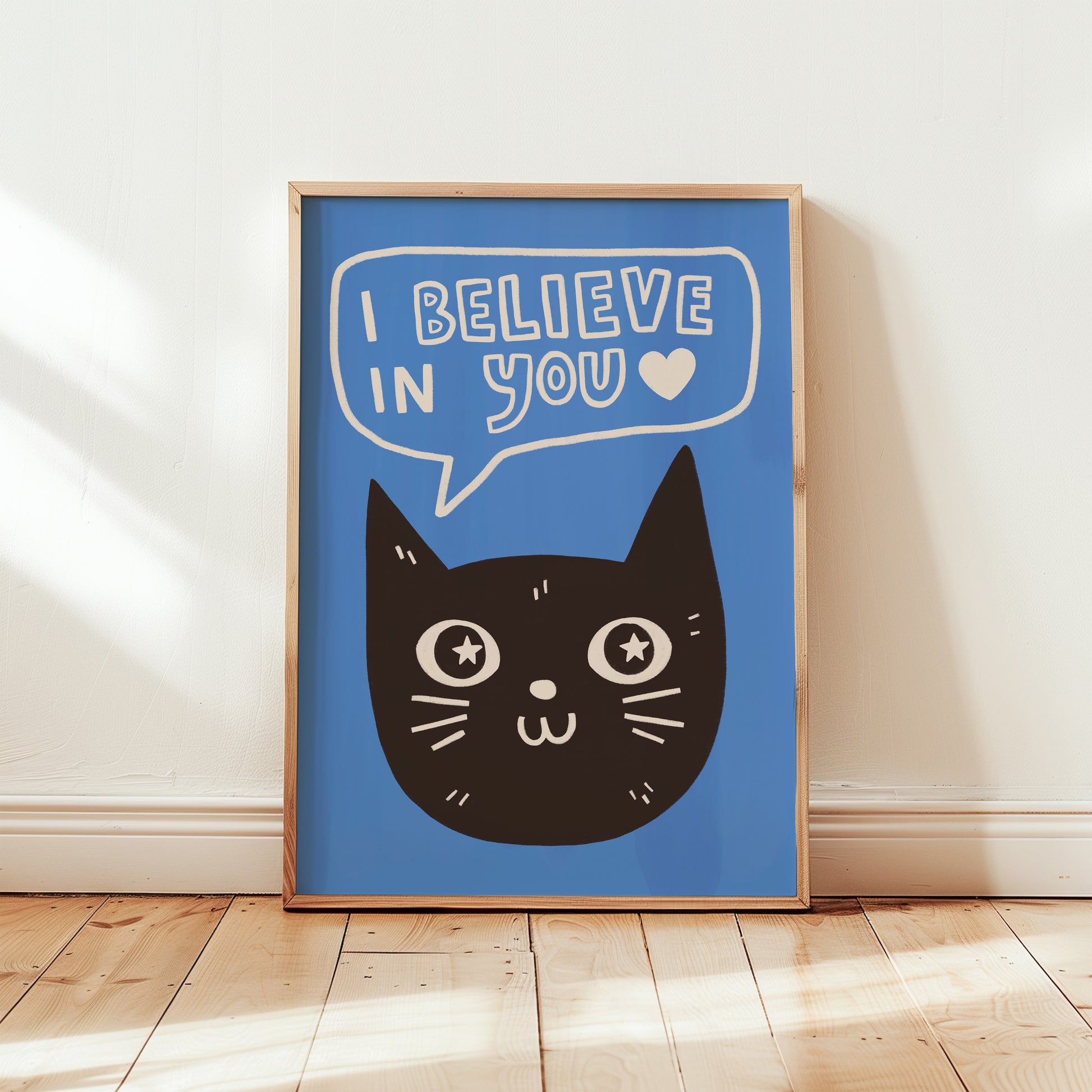 Unframed cat print wall art with black cat face and “I Believe in You” speech bubble on blue background