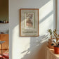 Framed cat spy print on wall with window-bar design and 'NEIGHBOURHOOD SPY' text, green accents.