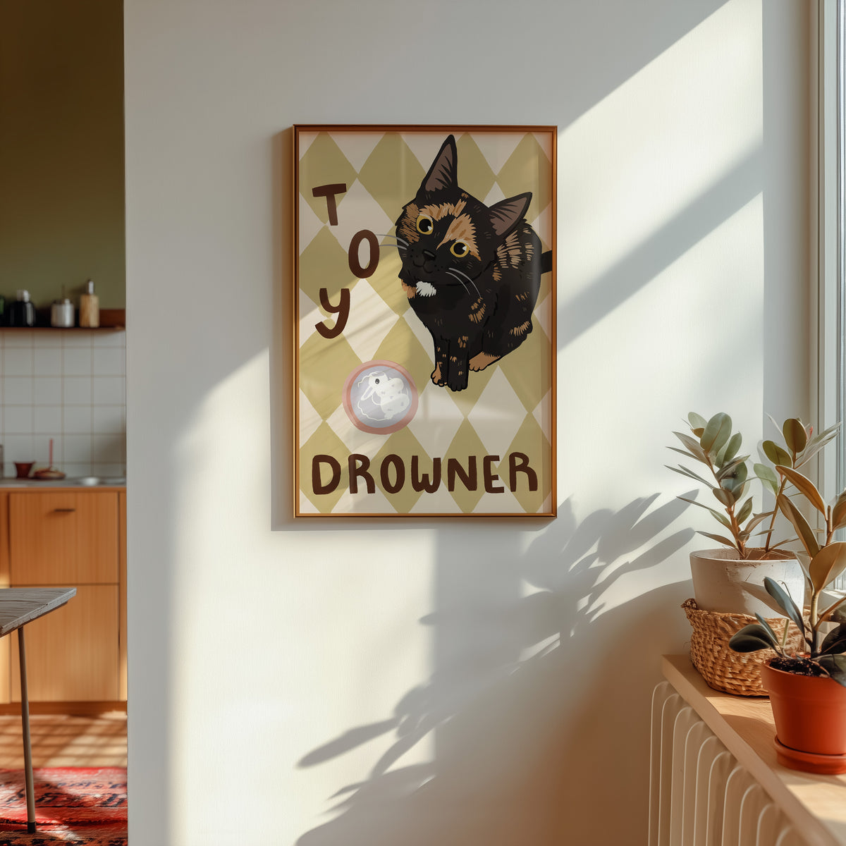 Framed cat print on wall with black kitten, 'TOY' and 'DROUNER' text, pink toy icon