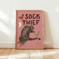 Framed cat print: 'SOCK THIEF' text, gray cat with red, white, and green sock icons
