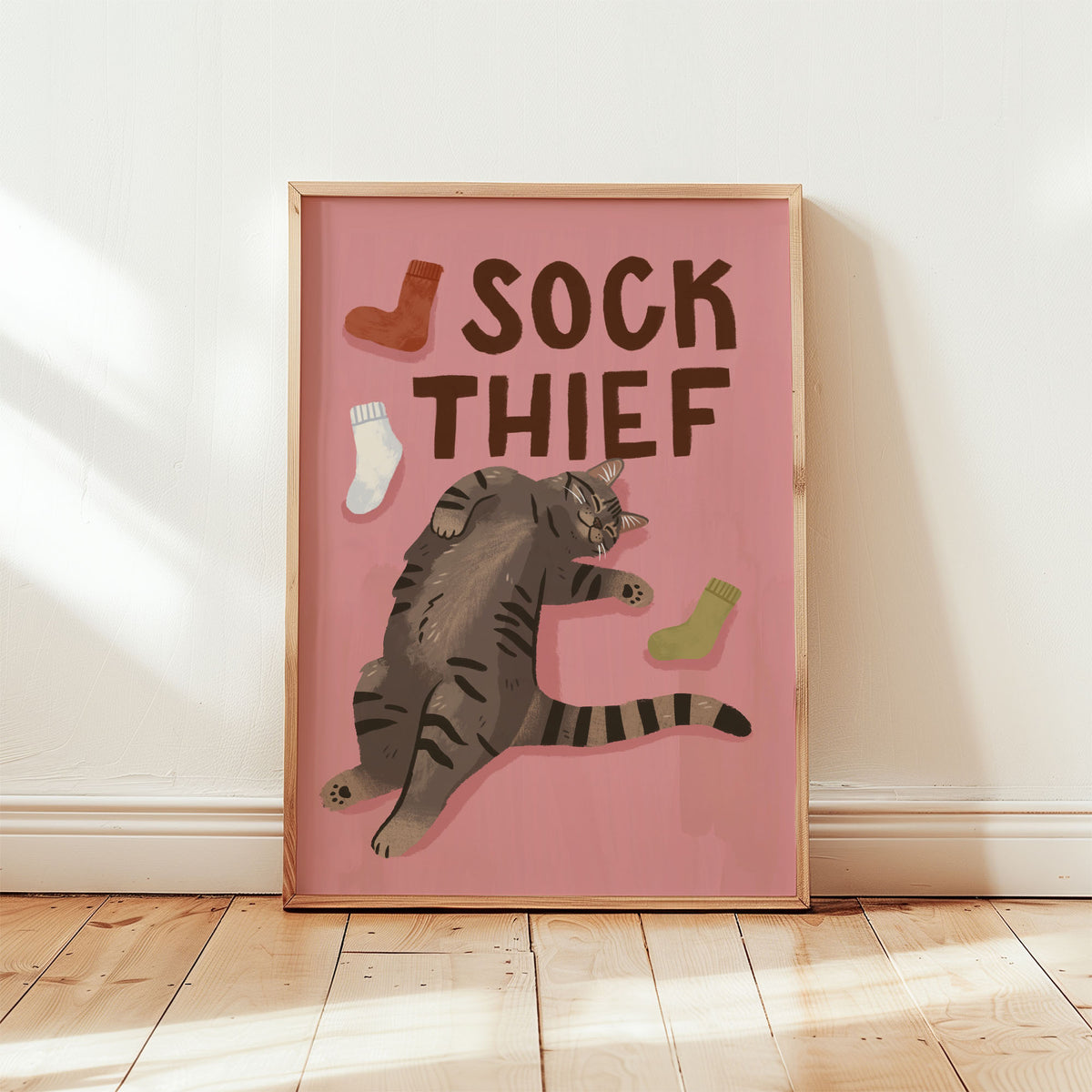 Framed cat print: 'SOCK THIEF' text, gray cat with red, white, and green sock icons