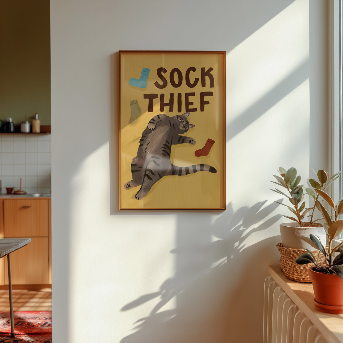 Framed cat print: 'SOCK THIEF' lettering, gray cat with brown and blue sock icons
