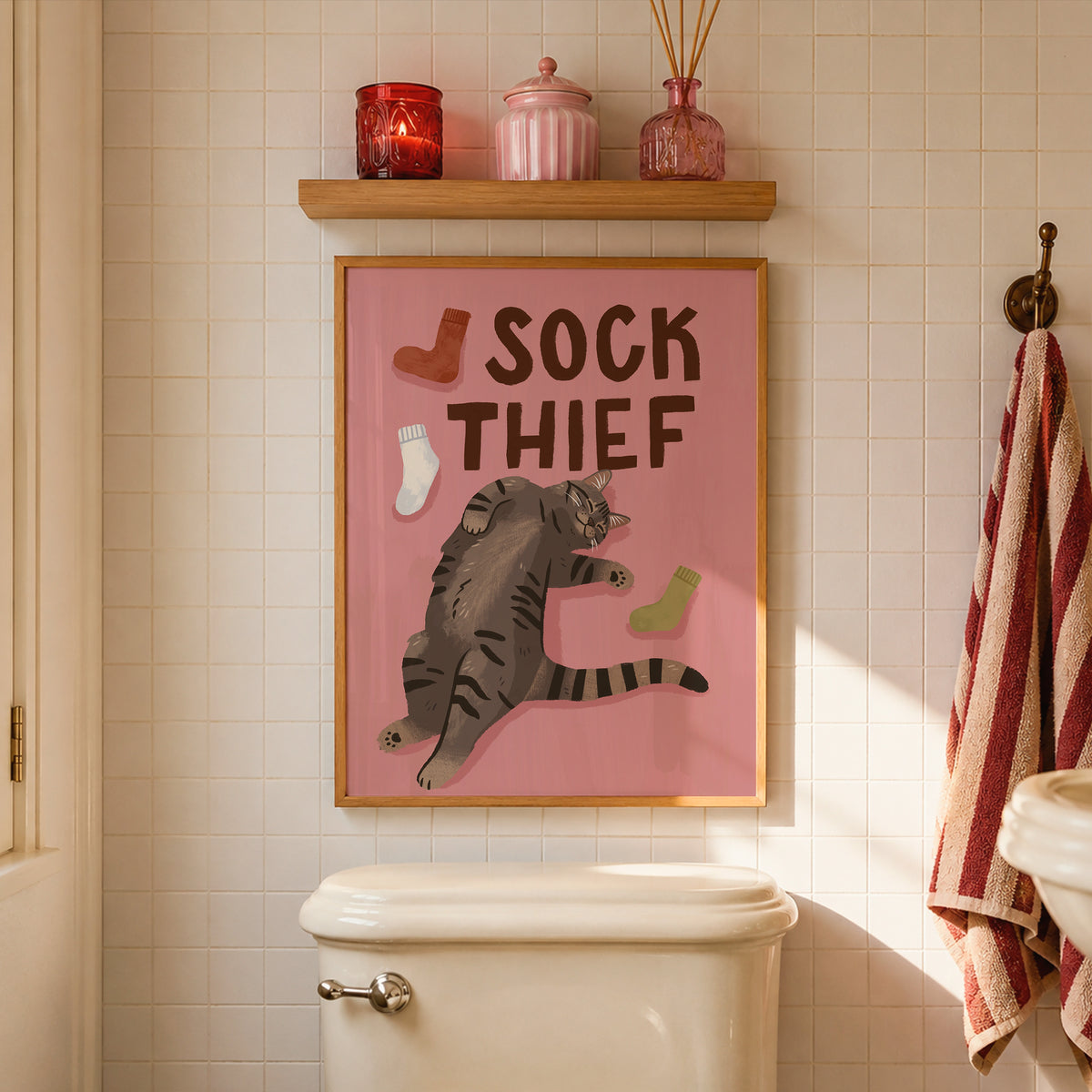 Framed cat print: 'SOCK THIEF' text with gray tabby cat and red, green, and white socks