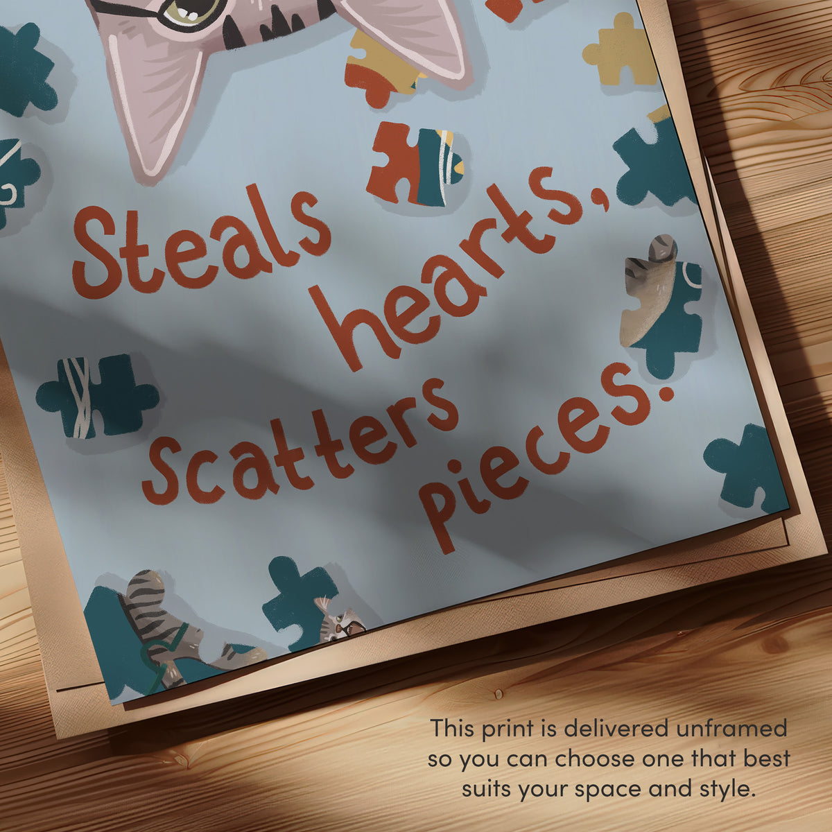 Close-up of unframed cat puzzle print border with “Steals hearts, scatters pieces” text