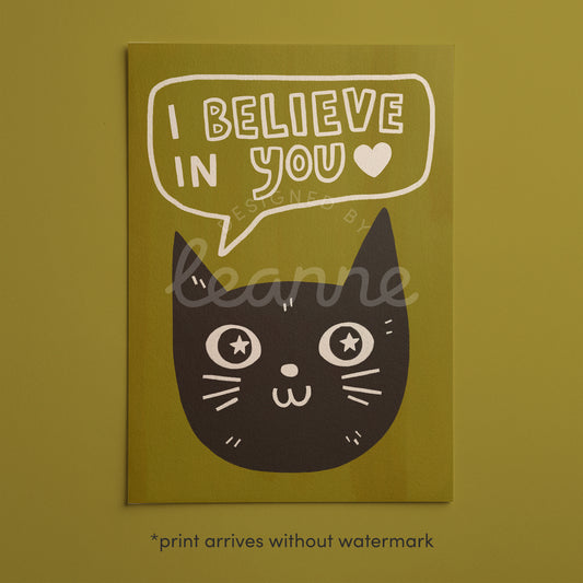 Unframed cat print wall art with black cat face, star eyes, and “I Believe in You” on green background