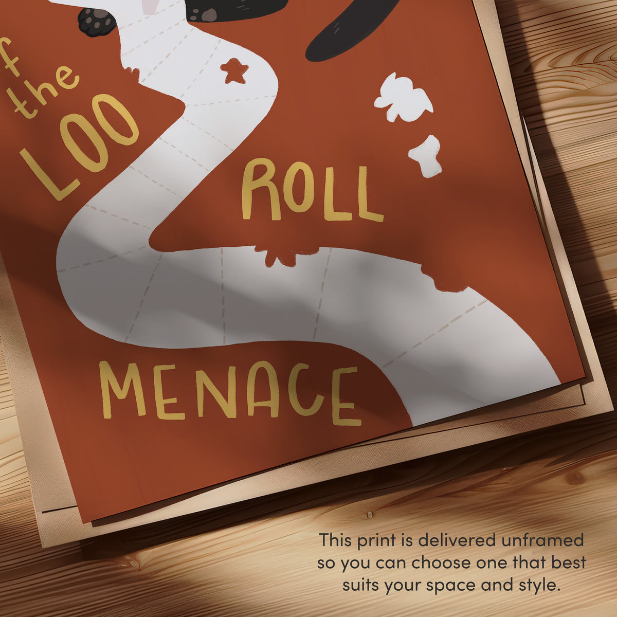 Close-up cat toilet paper print with text 'ROLL' and 'MENACE' on orange paper