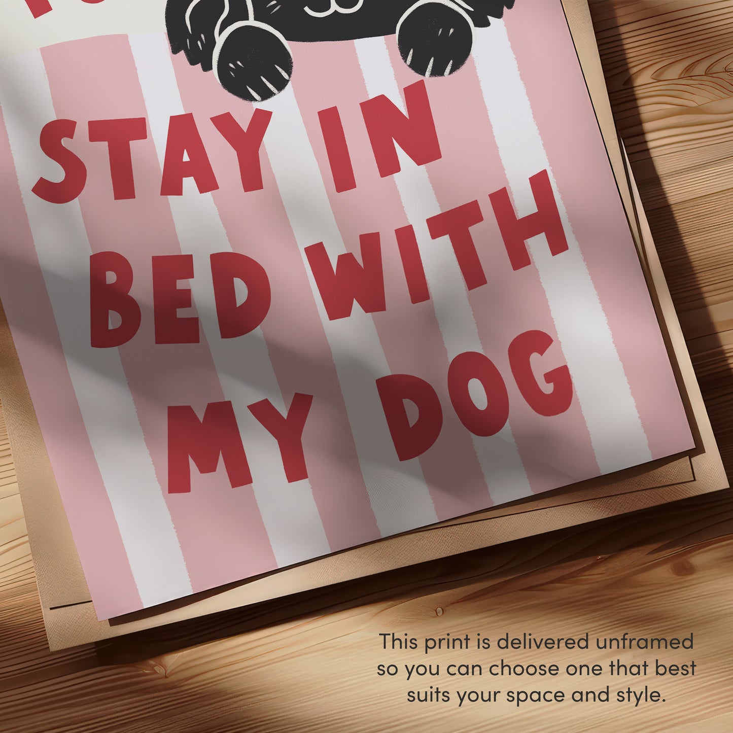 Close-up of “Stay in Bed with My Dog” text on pink-and-white striped print