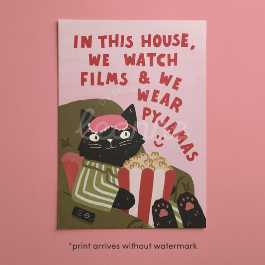 Cat pyjamas wall print with popcorn, “In this house we watch films…” on pink background